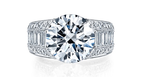 an engagement ring with a wide band and a large round cut diamond center stone as well as numerous accent stones