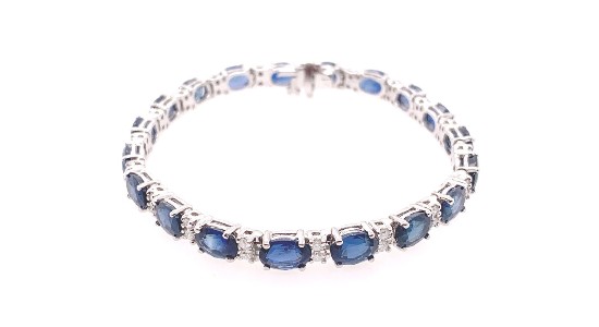 a white gold bracelet featuring oval cut sapphires and diamonds