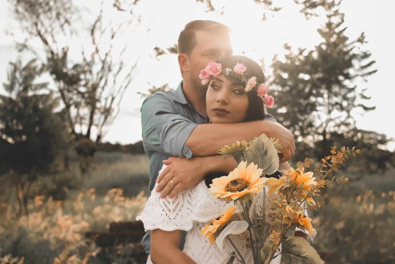 a man wearing a wedding band and embracing a woman